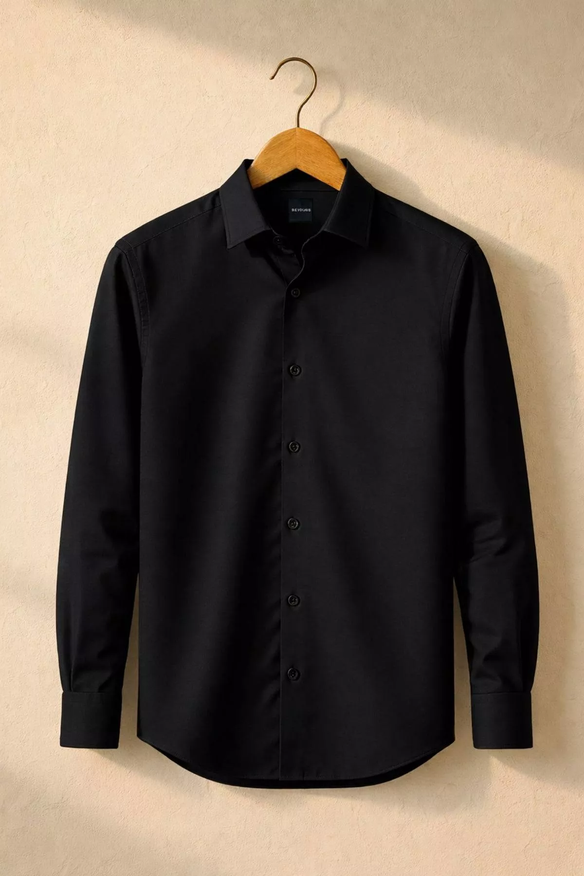 Men's Black Shirt in Jalandhar displayed on a hanger, showcasing its sleek design and breathable fabric for all-day wear.