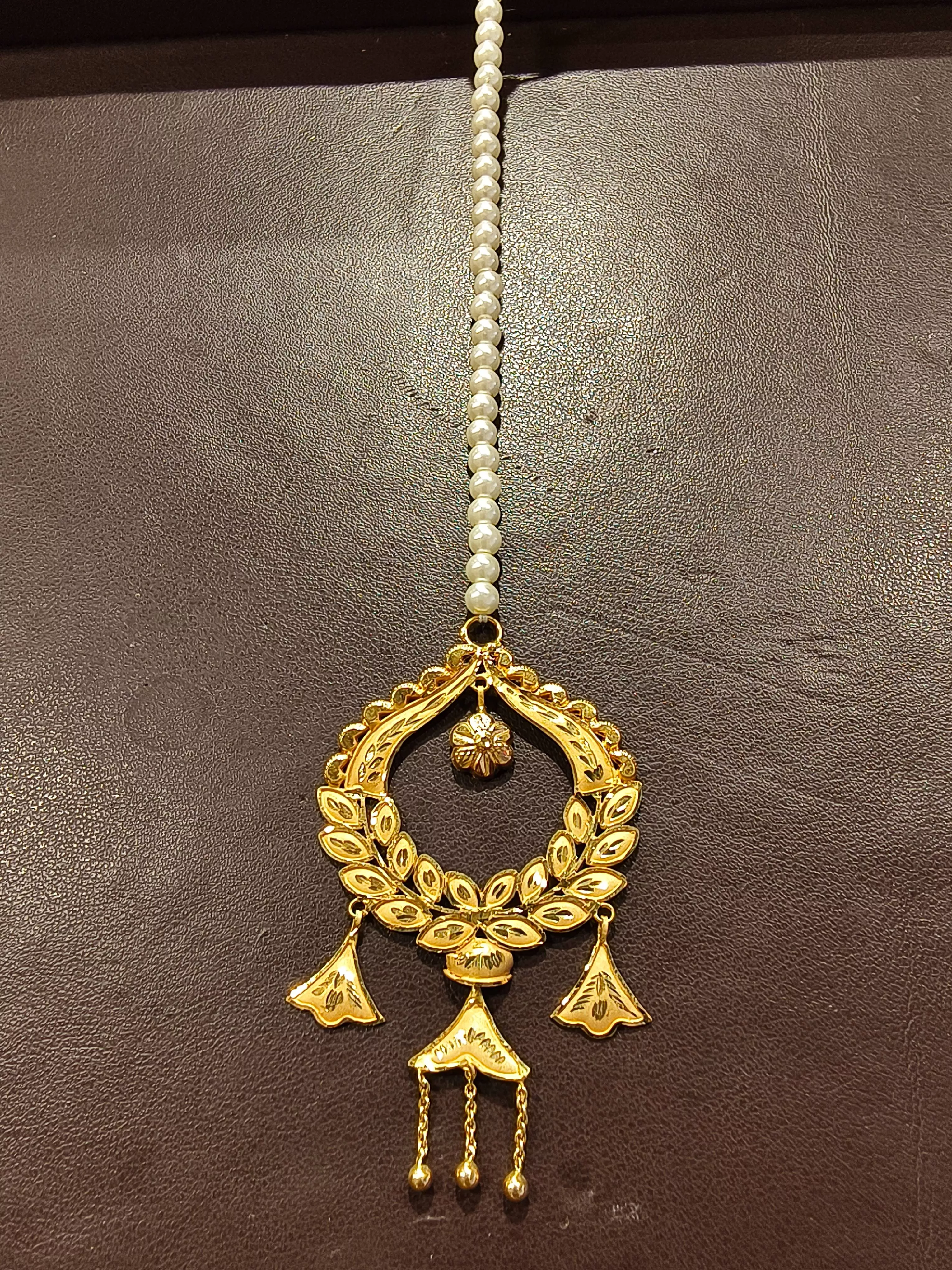 Gold-plated maang tikka with intricate leaf design and pearl accents, showcasing elegance in TWENTYFOUR NORTH PARGANAS.