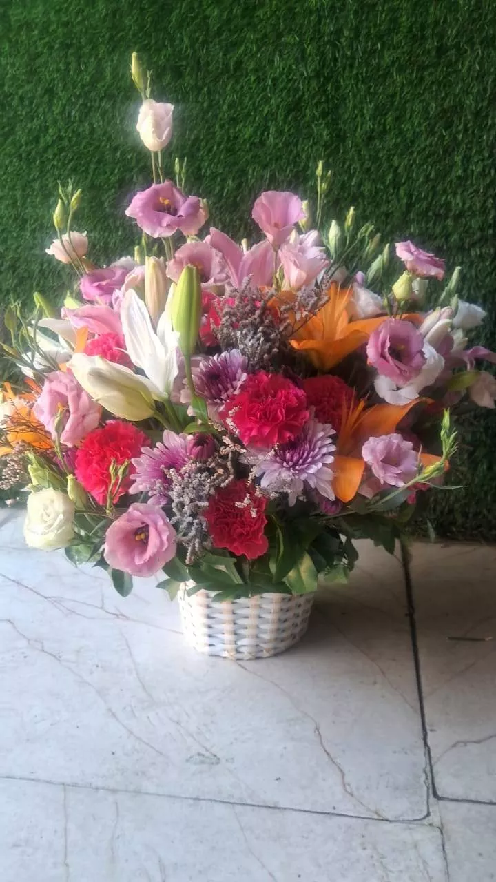Elegant Blossom Basket filled with mixed fresh flowers in vibrant colors, showcasing roses, lilies, and seasonal blooms from 