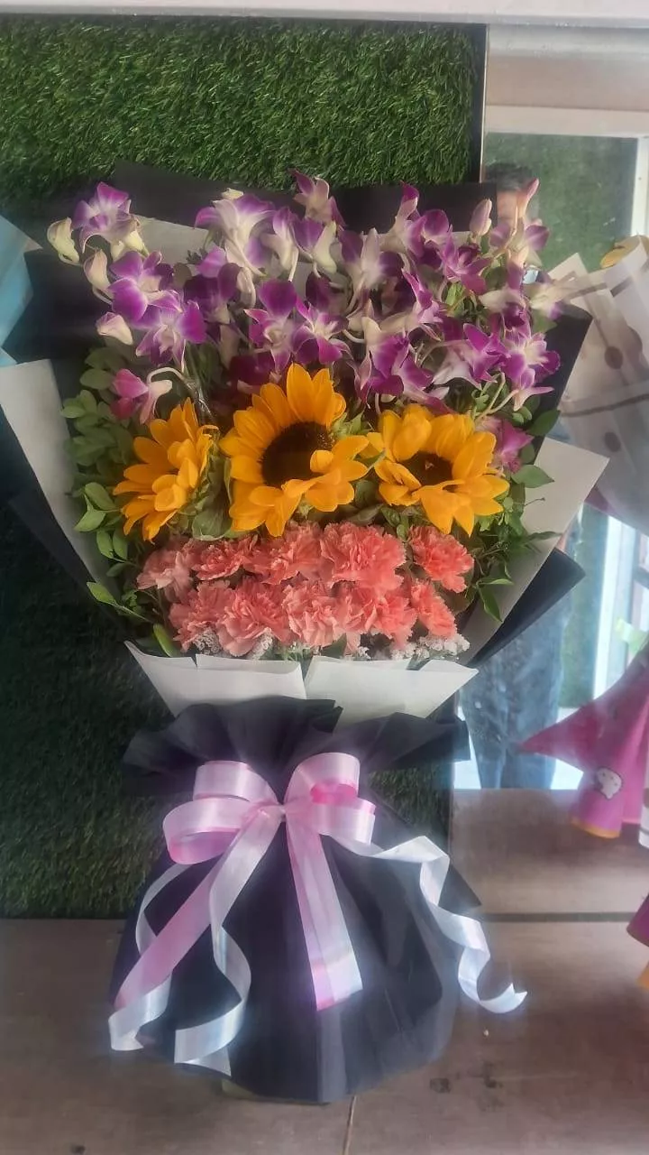 Vibrant Flower Arrangement featuring sunflowers, orchids, and carnations, showcasing bright colors in a beautiful bouquet, av