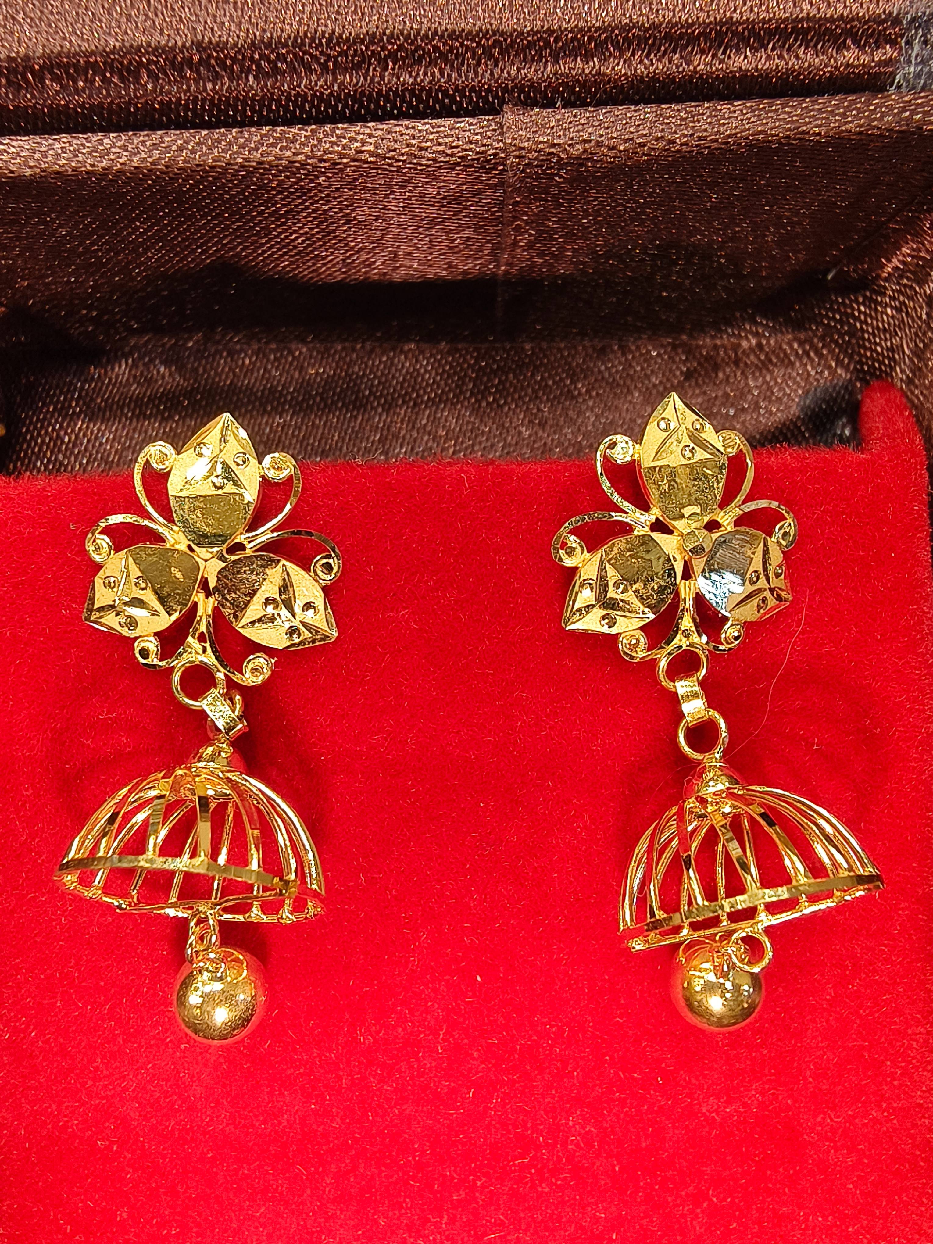 Elegant golden jhumka earrings with floral design and dangling elements showcased against a soft background in TWENTYFOUR NOR