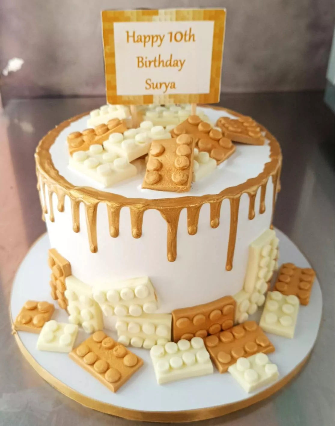 Custom Lego-Themed Birthday Cake featuring golden accents and white frosting from VARNIKA PATISSERIE in Bangalore, perfect fo
