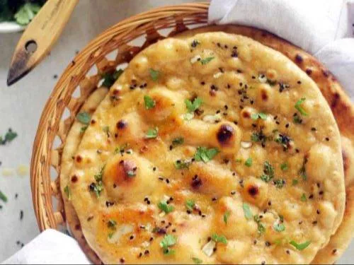 Freshly baked garlic butter naan from BALAJI GRAND, Sindhanur, showcasing a golden-brown color and soft texture, garnished wi