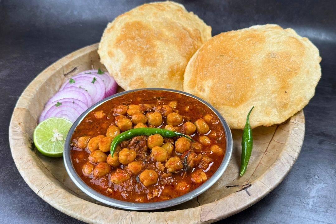 Delicious chhole bhature served with spicy chickpeas and fluffy bread from PARTEEK SWEETS AND RESTAURANTS in Chicpawan, showc