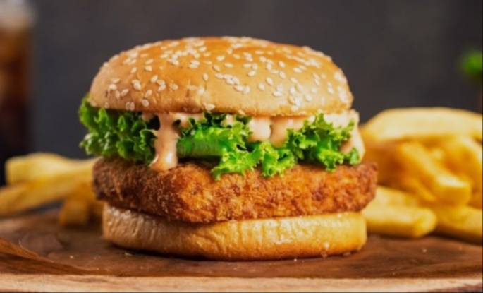 Delicious Chhili Paneer Burger served at FOUR 10 CAFE in Bhawanigarh, showcasing a crispy paneer patty and spicy sauce.